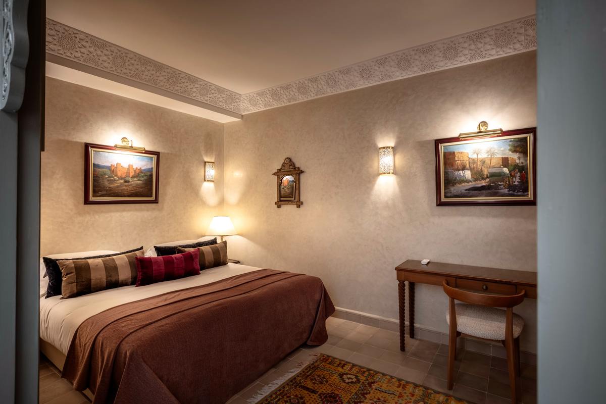 The Gallery Room seen from the archway, framed paintings above the bed