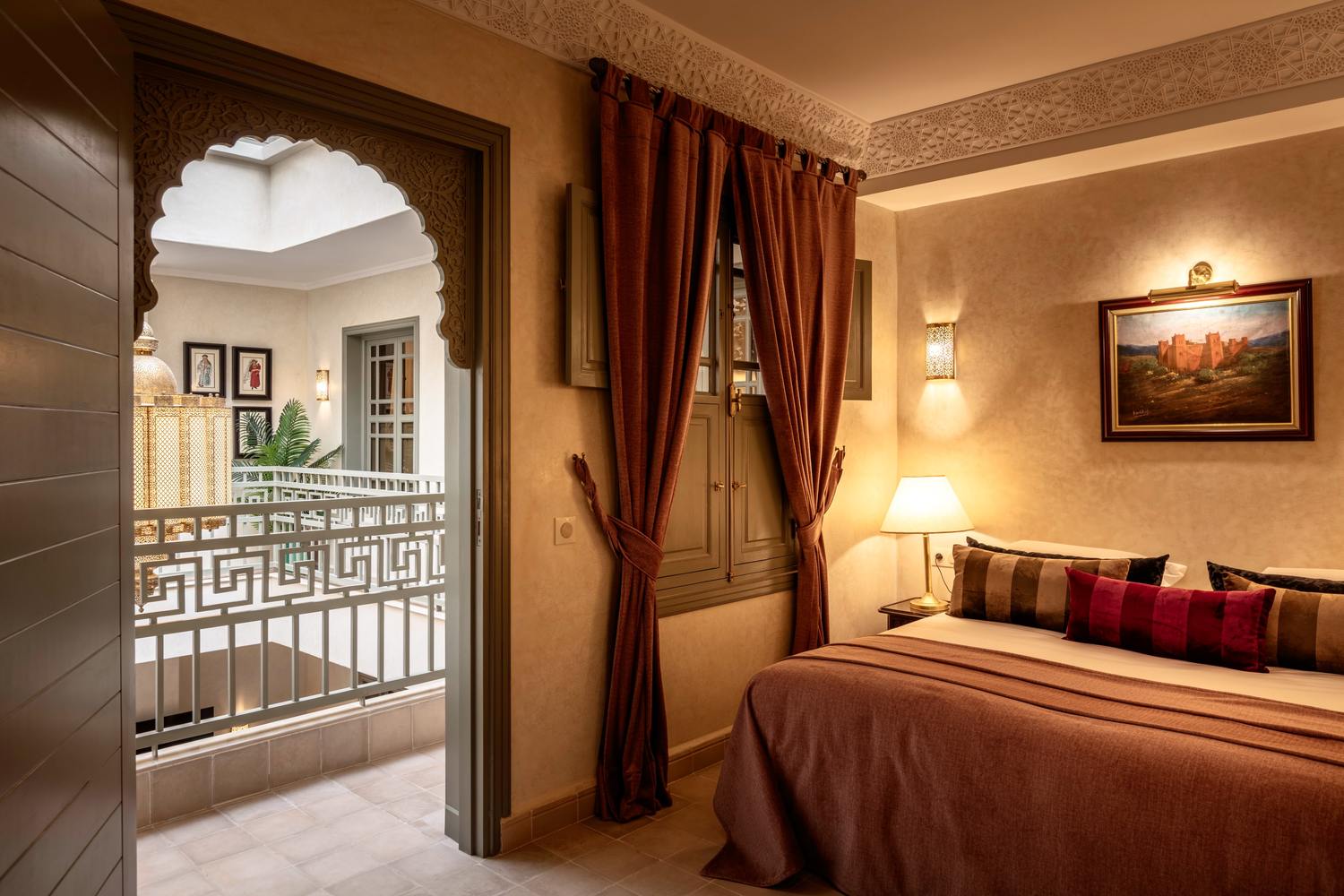 The Gallery Room: a king bed, with a carved archway opening onto the upper gallery