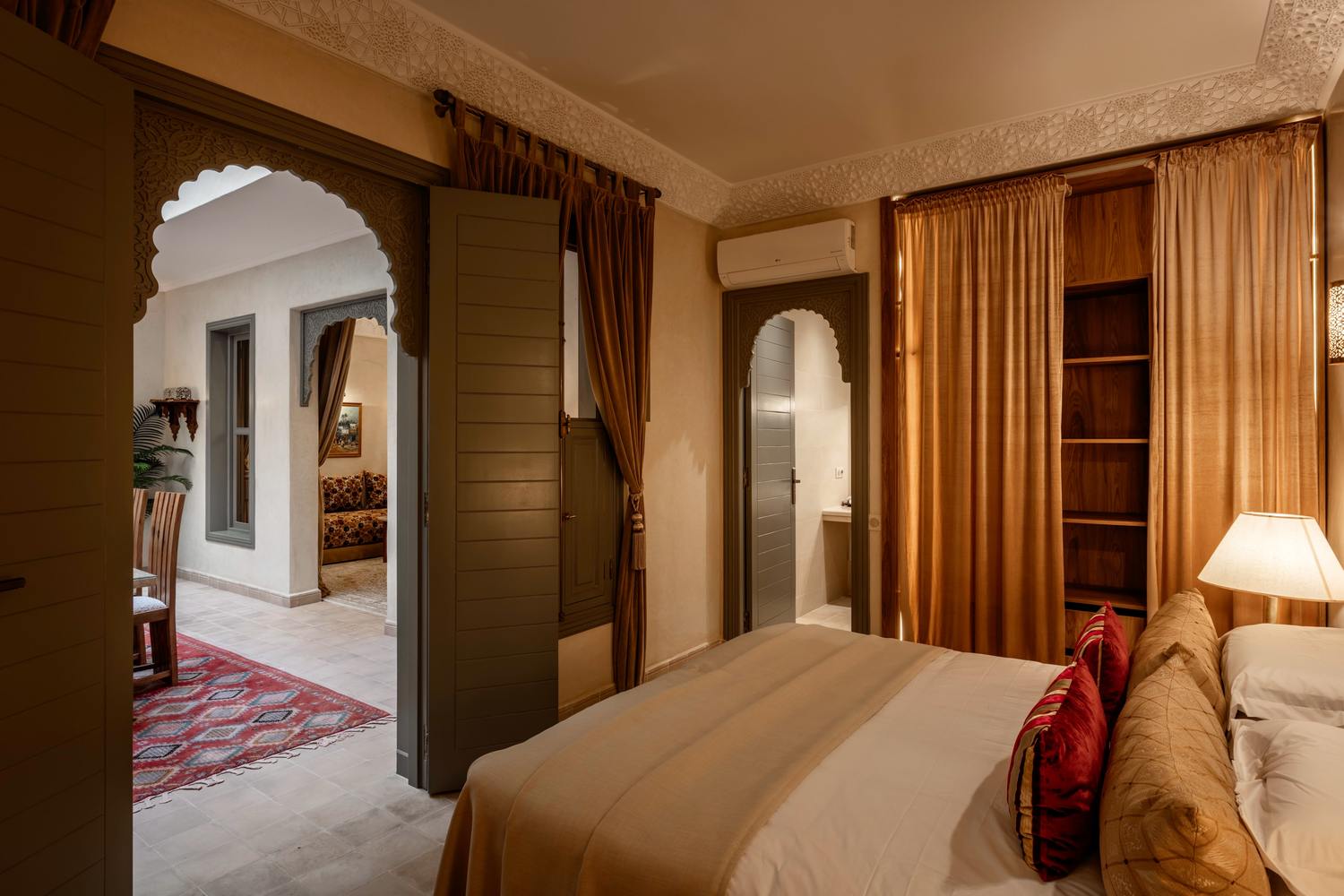 The Patio Room: a king bed, with an archway and shutters opening toward the patio
