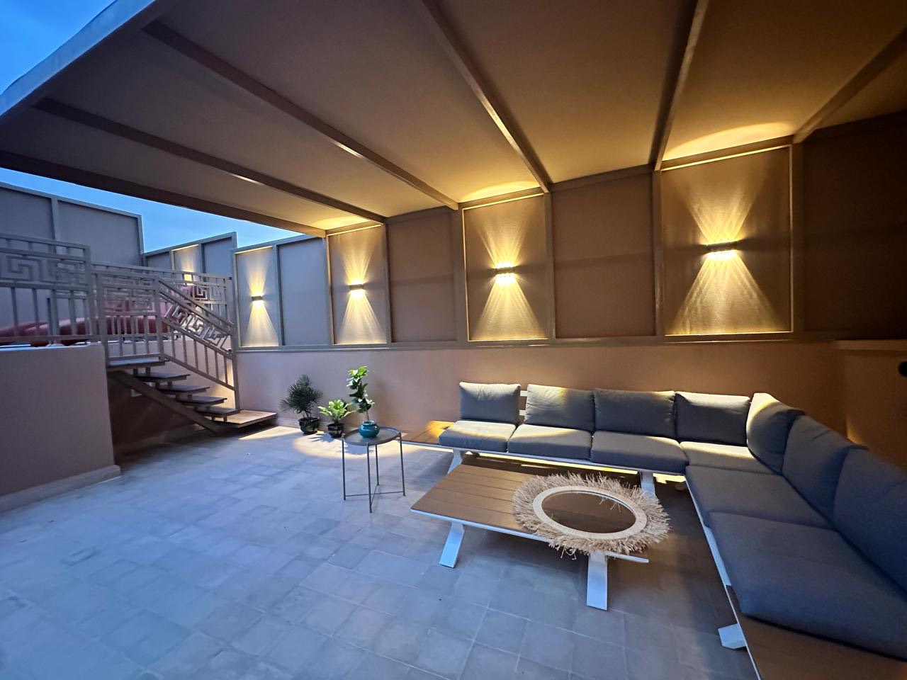 The covered rooftop lounge by day, with a long sectional sofa and low table