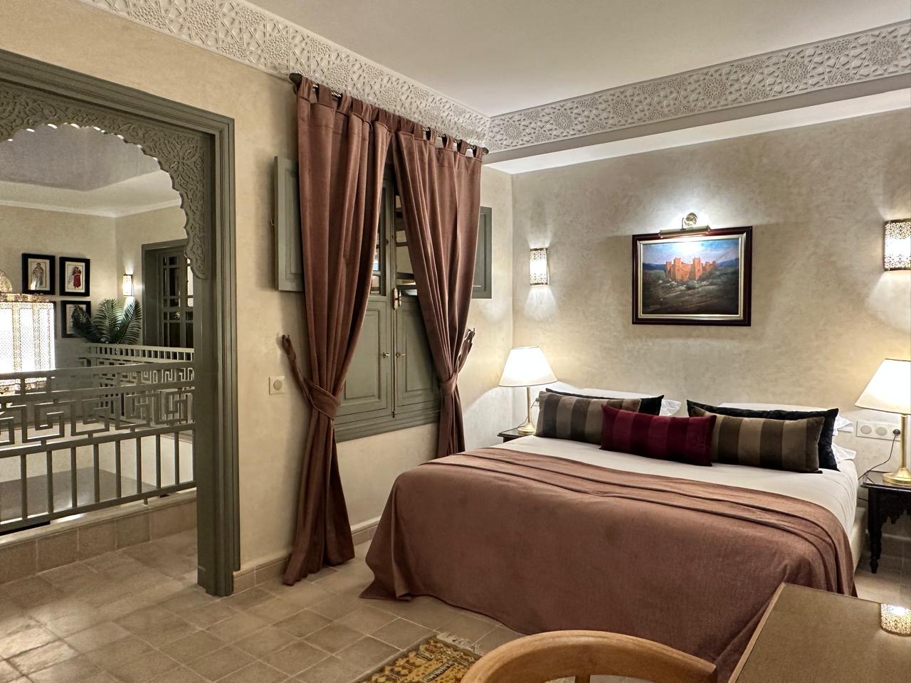 The suite bedroom, opening through a carved archway into its own sitting room