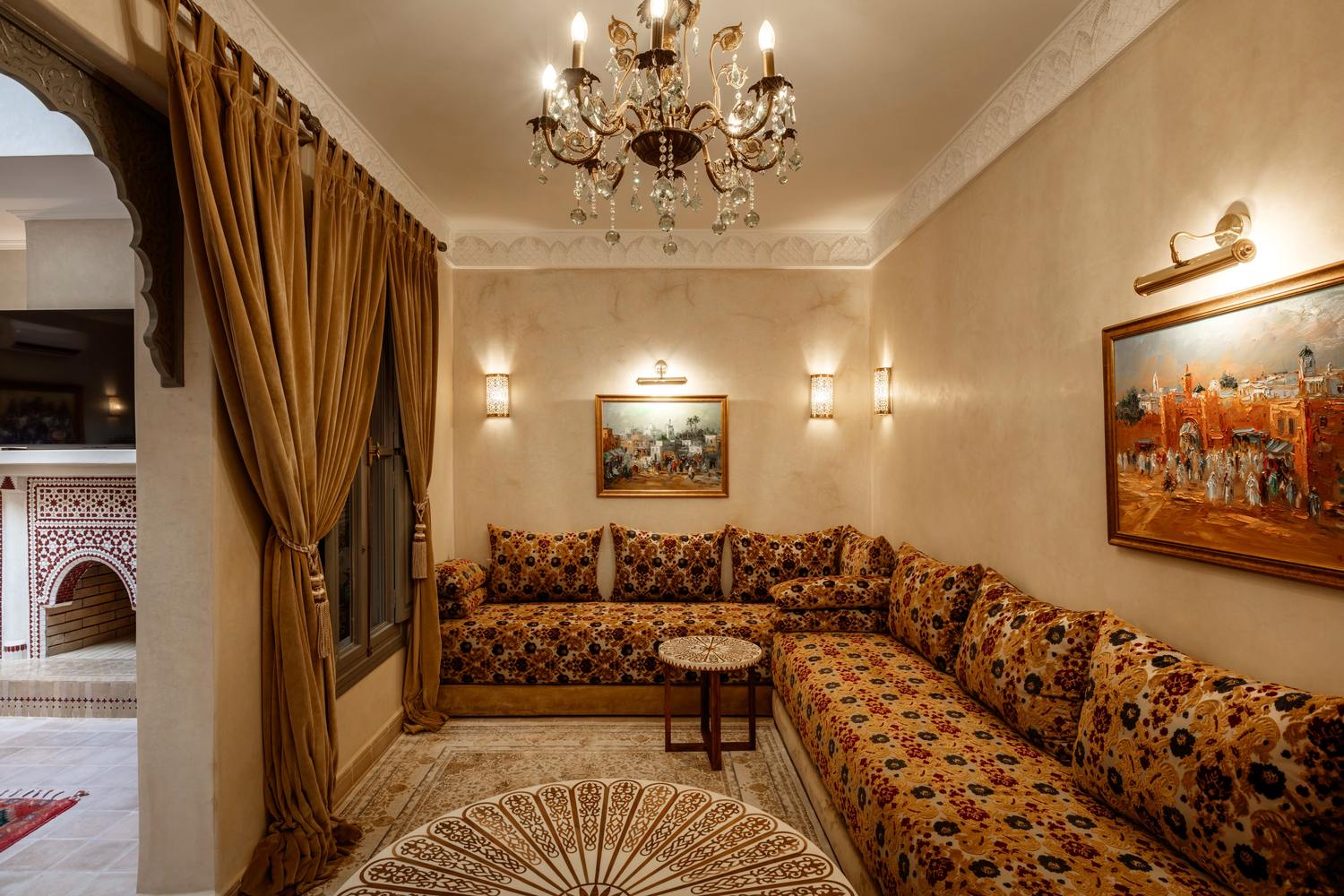 The Moroccan salon: banquettes running the length of two walls, deep cushions and painted scenes of the old city