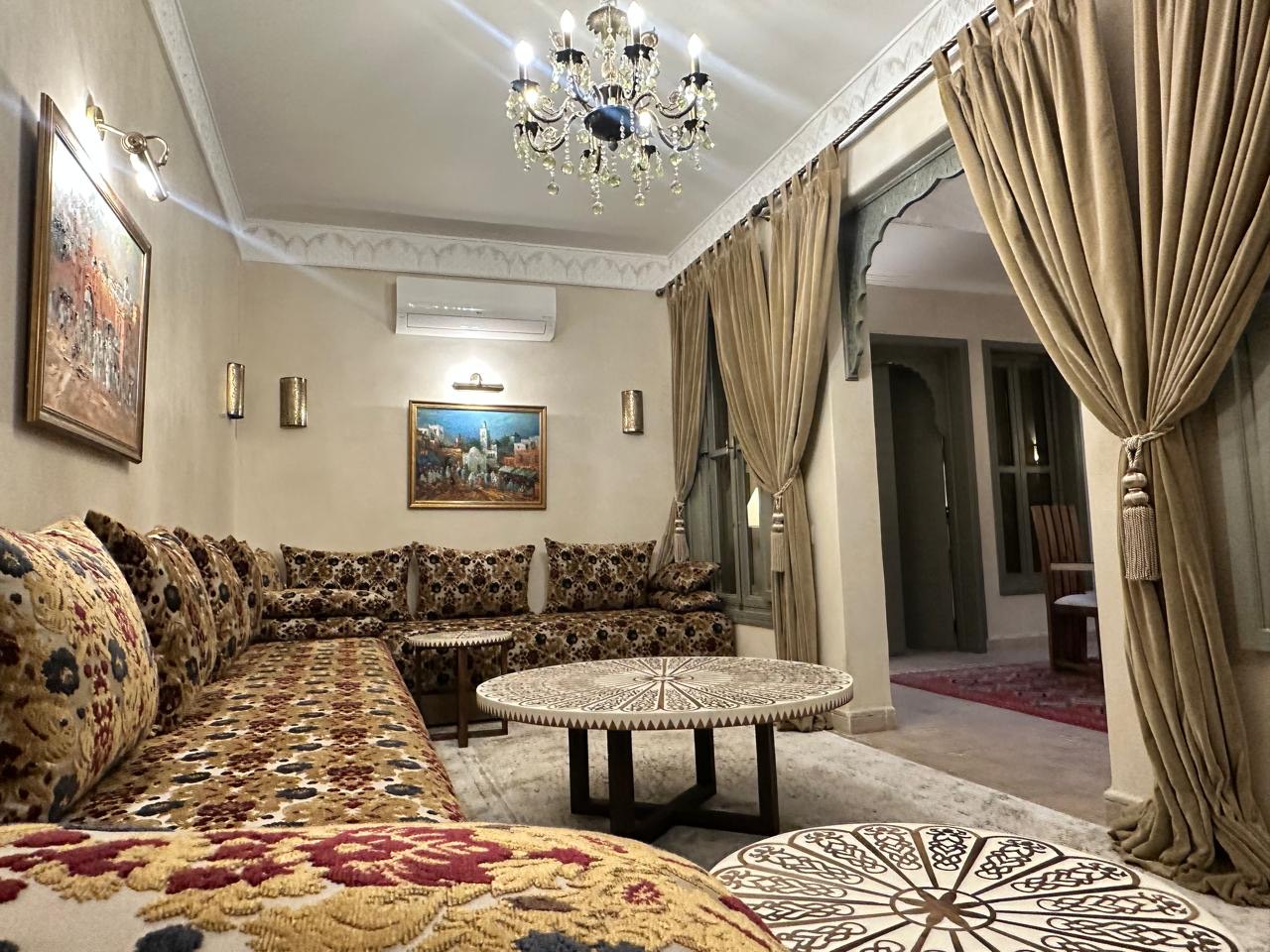 The Moroccan salon, banquettes running the length of two walls beneath framed paintings