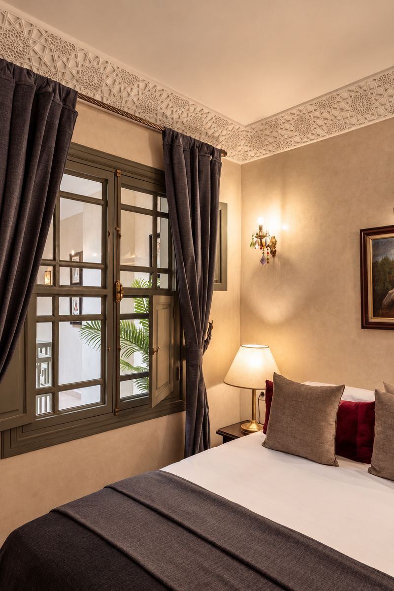 The Suite's bed beside shuttered windows onto the gallery