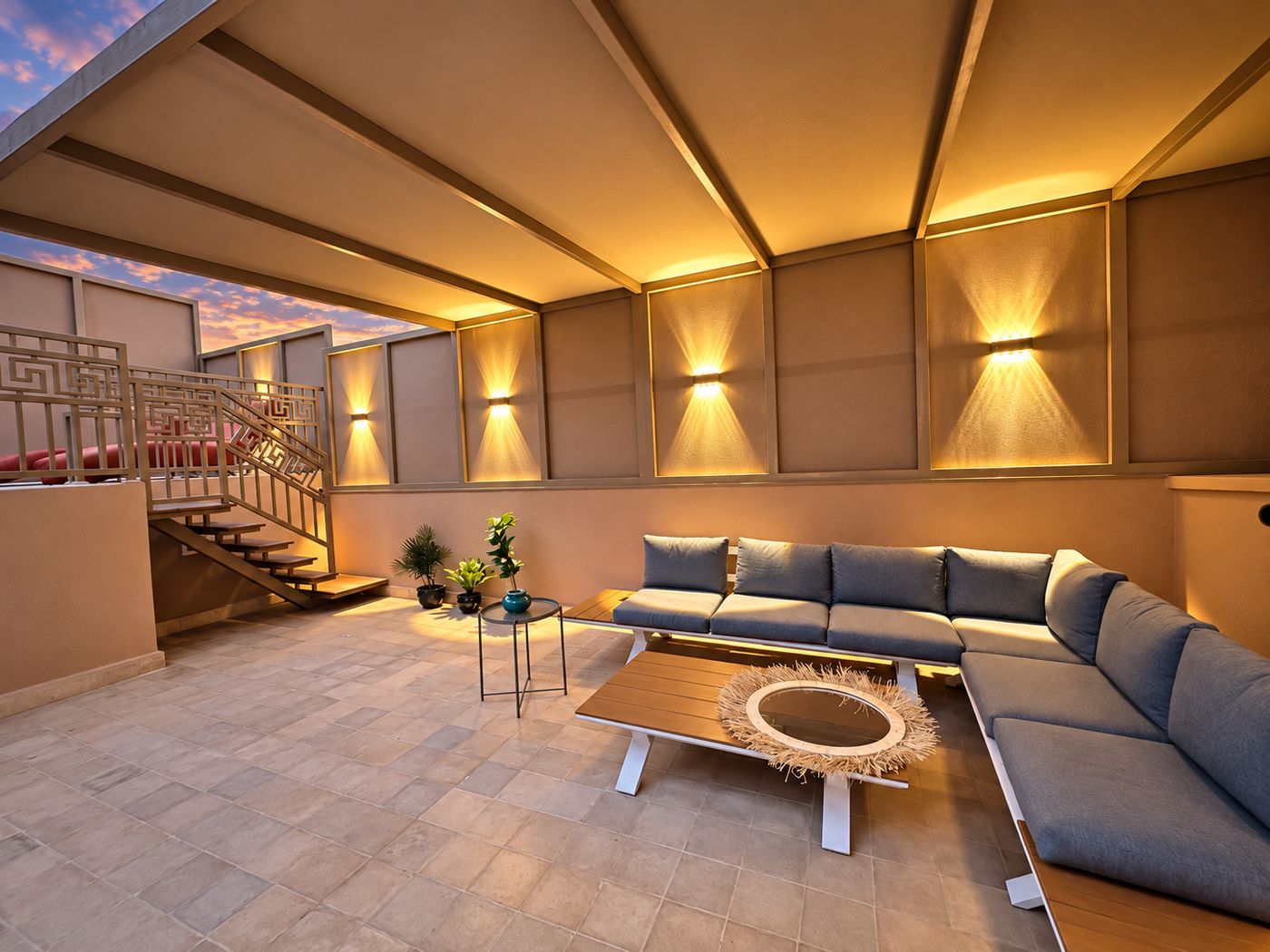 The rooftop lounge in the evening, wall lights washing the panelled walls above the sectional sofa